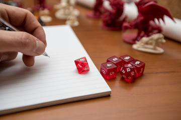 Pen, notebook and dices to play role game like dungeons and dragons. Writing with the mechanical...