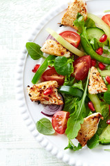 Healthy Salad with Pomegranate seeds, Chicken Briest, Green Pepper and fresh Basil. Bright wooden background. Top view.