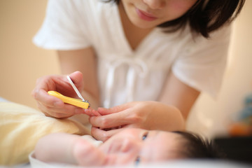 Obraz na płótnie Canvas 赤ちゃんの爪を切る母親
