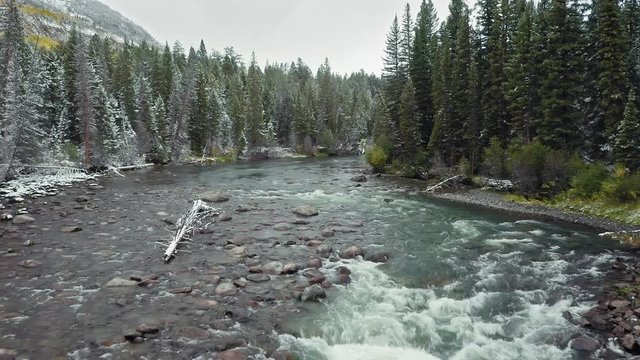 Aerial: Clarks Fork Yellowstone river and forest covered in snow. The river runs through Yellowstone National Park. Wyoming, USA
