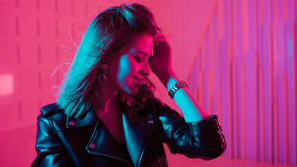 Beautiful girl dancing in retro wave on the neon light