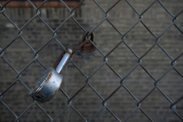 closeup of old lock on chainlink fence background