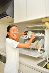 食洗器で食器を洗浄する女の子
