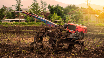A hand tractor is a popular farm equipment in the Indonesia. It is often used by farmers to work on rice fields. © Nabiru