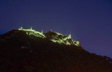 Evening view of the Moorish fortress on the hilltop above the city of Sintra illuminated at night