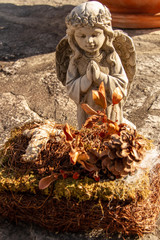 Angel statue kneeling with dried flowers