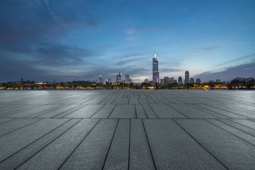 Panoramic skyline and buildings with empty square floor at dusk