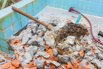 repair toilet old bathroom interior house and with Large steel hammer