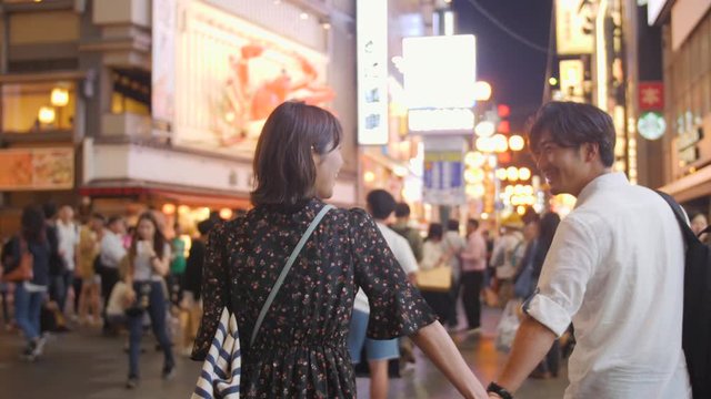 Dreamy Asian couple Romantic walk through Neon Lights of Osaka Nightlife