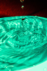 Drops of water falling on green pond macrophotography