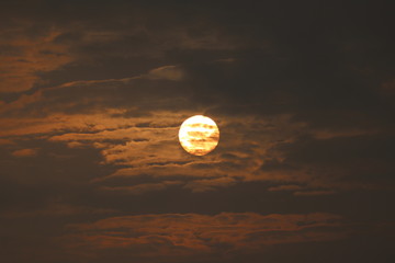 MORNING SUN SHINING BEHIND THE CLOUDS