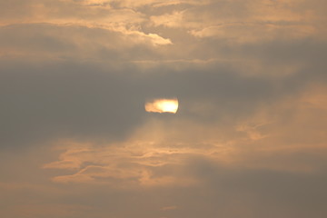 MORNING SUN SHINING BEHIND THE CLOUDS