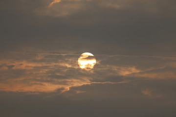 MORNING SUN SHINING BEHIND THE CLOUDS