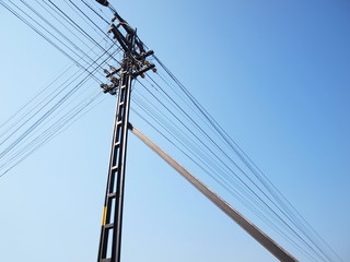 Supporting pillars or reinforced with metal On the background of the electricity pylon with many cables and blue sky While copying the space for the text