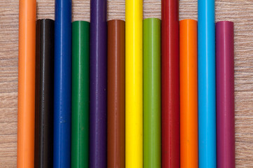 Concept back to school - frame of multicolored pensils on wood background