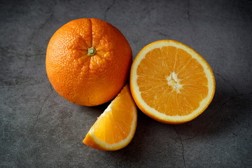 Ripe oranges on a dark gray background