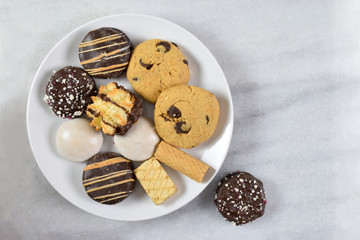 A variety of fresh baked cookies on a marble background with copy space