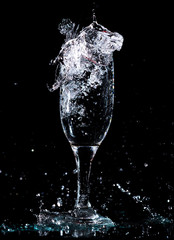 Water with splashes in a glass on a black background