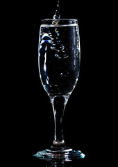 Water with splashes in a glass on a black background