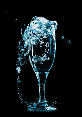 Water with splashes in a glass on a black background