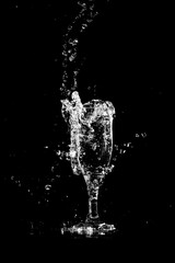 Water with splashes in a glass on a black background
