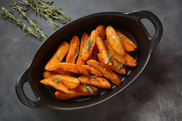 Baked, fried potato wedges with spices and rosemary. Roast potatoes with spices in the frying pan