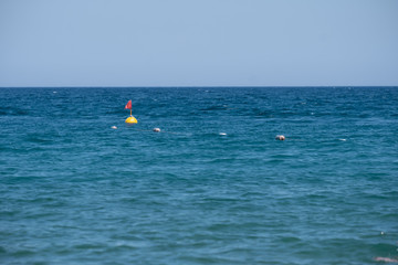 yellow buoy with a flag on the sea swim limiter