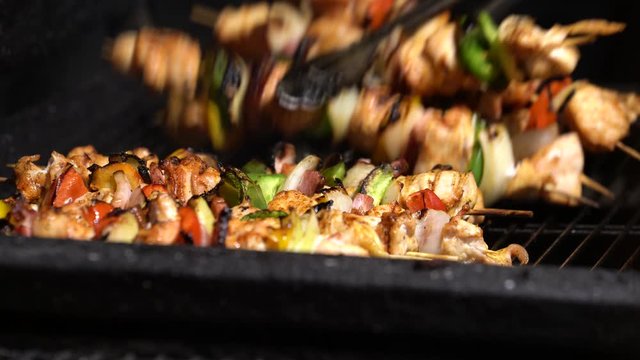 Chicken skewers being grilled on a coal grill