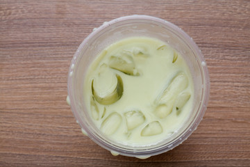 Milky Ice green tea on wooden table. View from above