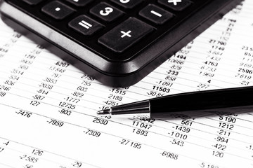 Financial concept. Calculator, pen and glasses on financial documents. Financial accounting. Balance sheets. Closeup of financial statements and annual reports. Business marketing