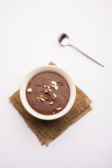 Sweet Ragi Malt / Healthy Ragi Porridge in a bowl garnished with crushed dry fruits