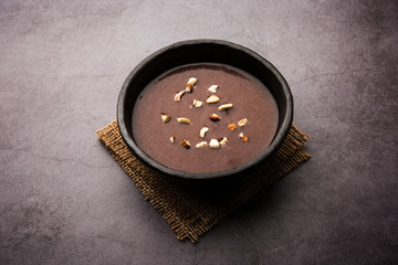 Sweet Ragi Malt / Healthy Ragi Porridge in a bowl garnished with crushed dry fruits