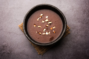 Sweet Ragi Malt / Healthy Ragi Porridge in a bowl garnished with crushed dry fruits