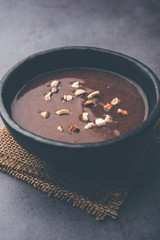 Sweet Ragi Malt / Healthy Ragi Porridge in a bowl garnished with crushed dry fruits