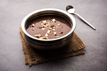 Sweet Ragi Malt / Healthy Ragi Porridge in a bowl garnished with crushed dry fruits