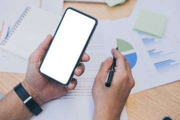 Mockup image blank white screen cell phone.man hand holding texting using mobile on desk at home office.background empty space for advertise text.people contact marketing business,technology 
