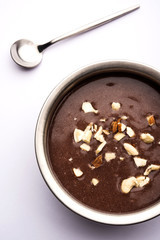 Sweet Ragi Malt / Healthy Ragi Porridge in a bowl garnished with crushed dry fruits