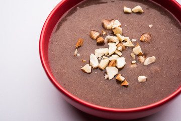 Sweet Ragi Malt / Healthy Ragi Porridge in a bowl garnished with crushed dry fruits