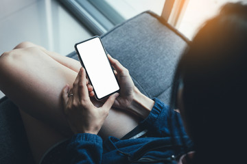 Mockup image blank white screen cell phone.woman hand holding texting using mobile on sofa at home office.background empty space for advertise text.people contact marketing business,technology 