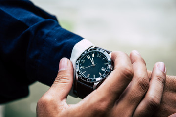 looking at luxury watch on hand check the time at workplace.concept for managing time organization working,punctuality,appointment.fashionable wearing stylish