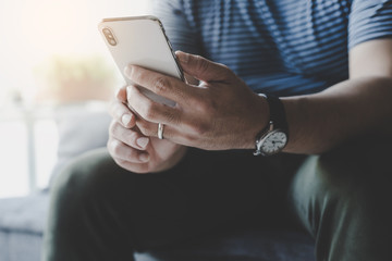 using cell phone.hand holding texting message on screen mobile chatting friend ,search internet information sitting on sofa in office.technology device contact communication connecting people concept