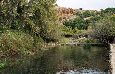 Fototapeta na wymiar tourists at the banias springs in the israel national park on the hermon stream showing the vegetation and the pools constructed in ancient times