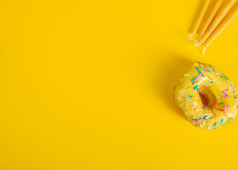 colorful doughnuts candles yellow background studio