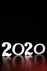 new year 2020 letters on a shiny surface and a black background