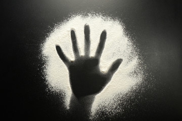 Drawing flour on a black board. Palm