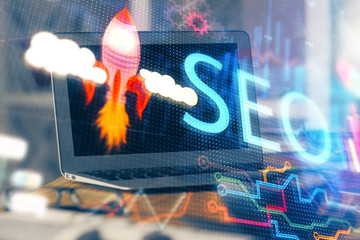 Multi exposure of table with computer and seo drawing hologram. Search optimization concept.