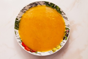 bowl with pumpkin soup on background