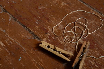 wooden clothespin and thread on a wooden background
