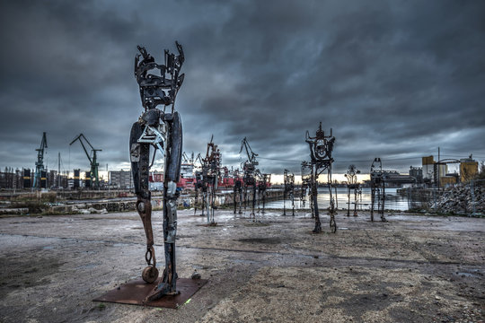 Gdansk, Poland - December 15, 2019: Sculptures of Czesław Podlesny called Survivors made of scrap walking out of the water in the former shipyard of Gdansk, Poland