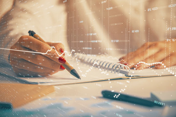 Double exposure of woman's hands making notes with forex graph hologram. Concept technical analysis.